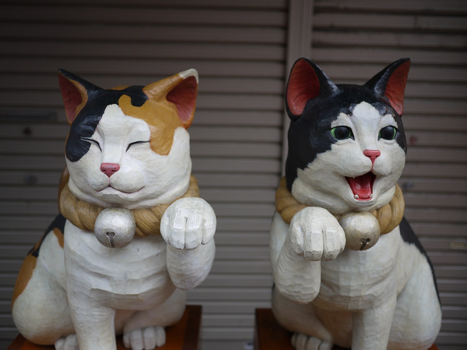 谷中銀座の店先に置かれた二体の木彫りの招き猫